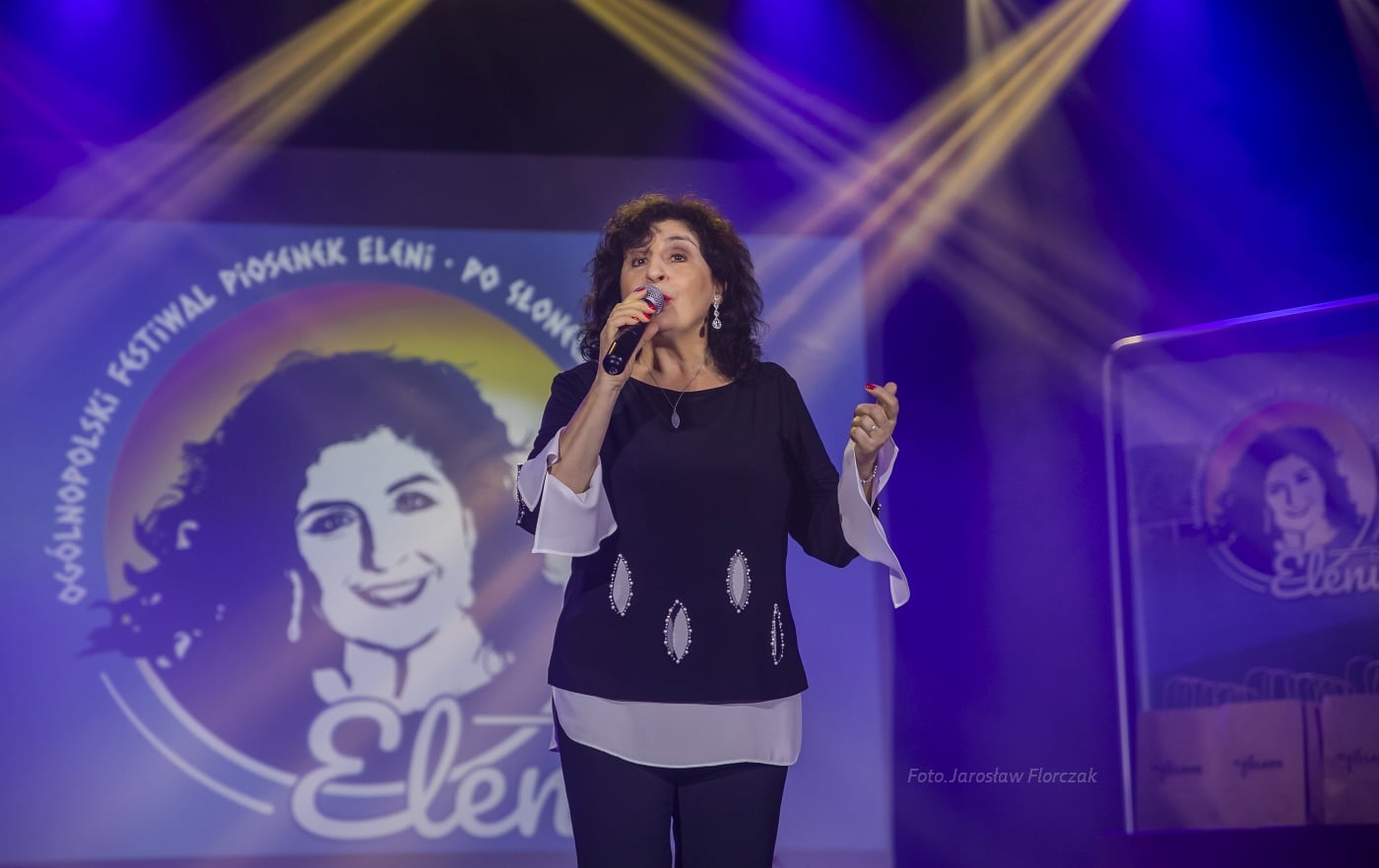 Eleni na scenie. W tle logotypy Festiwalu Piosenek Eleni