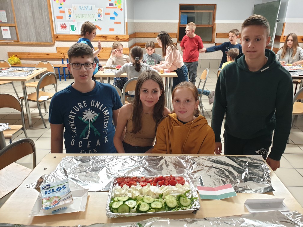 na zdjeciu 4 uczniów oraz klasa w tle