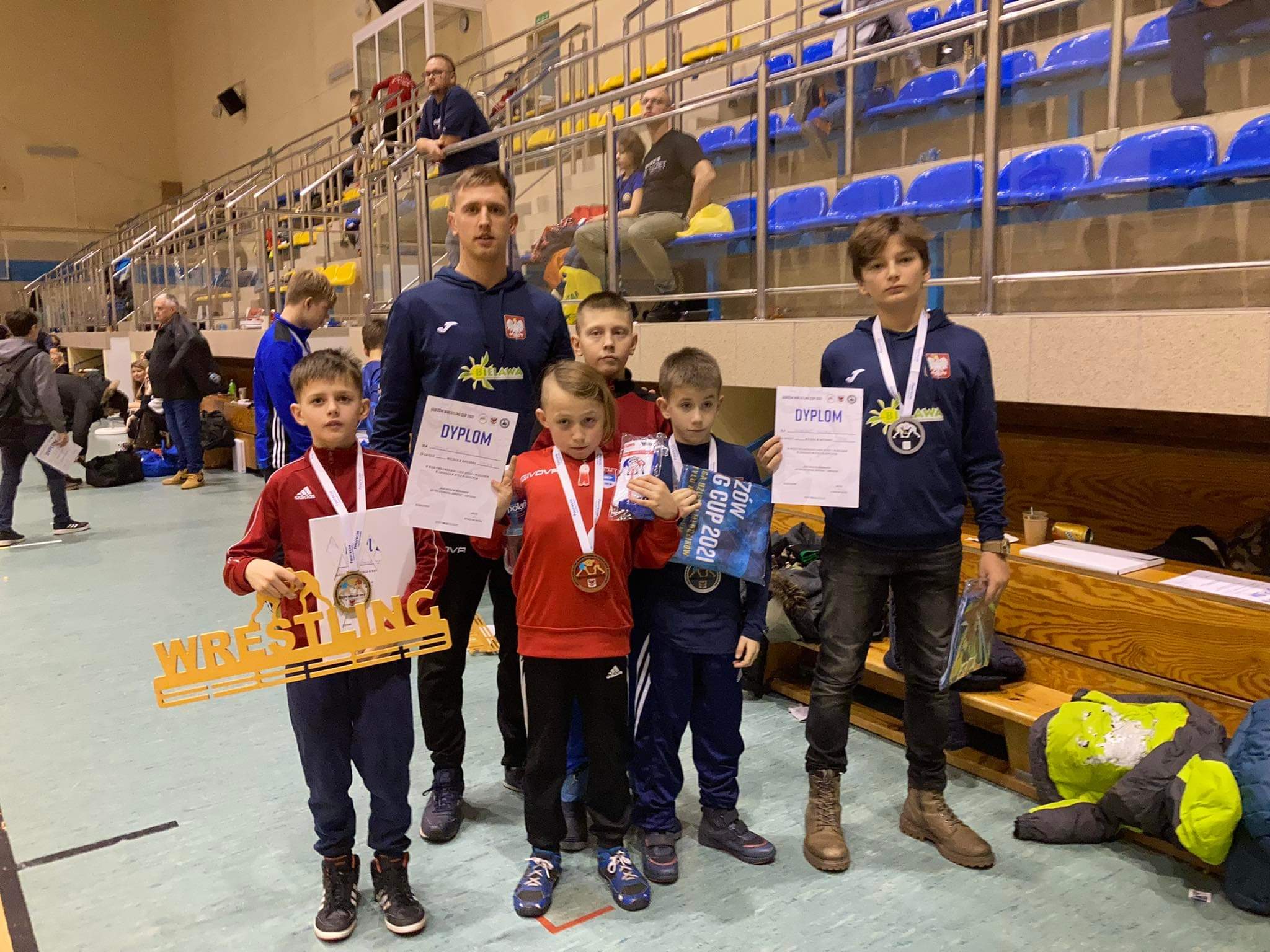 Zawodnicy ZKS Bielawianka z medalami i dyplomami z opiekunem w hali sportowej