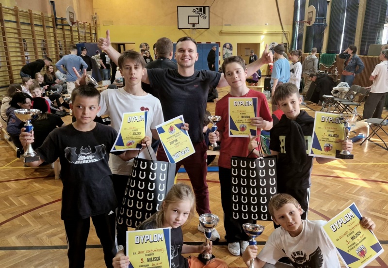 Zawodnicy BWA BREAKERS z trenerem i zwycięskimi trofeami