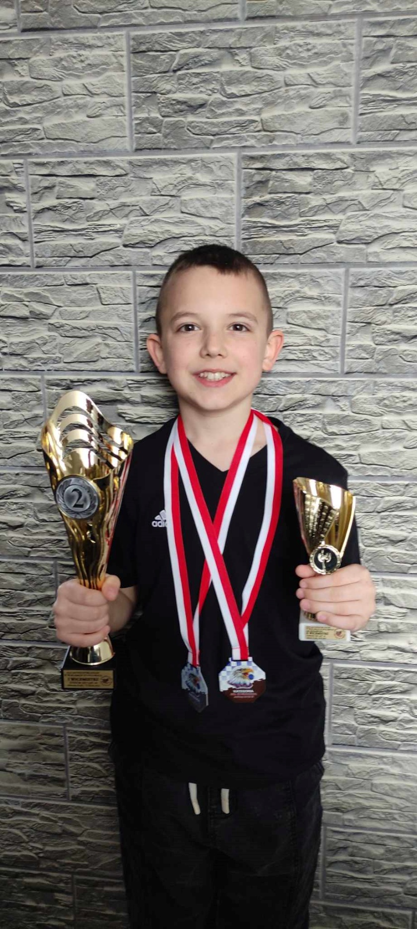Wojciech z pucharami i medalami
